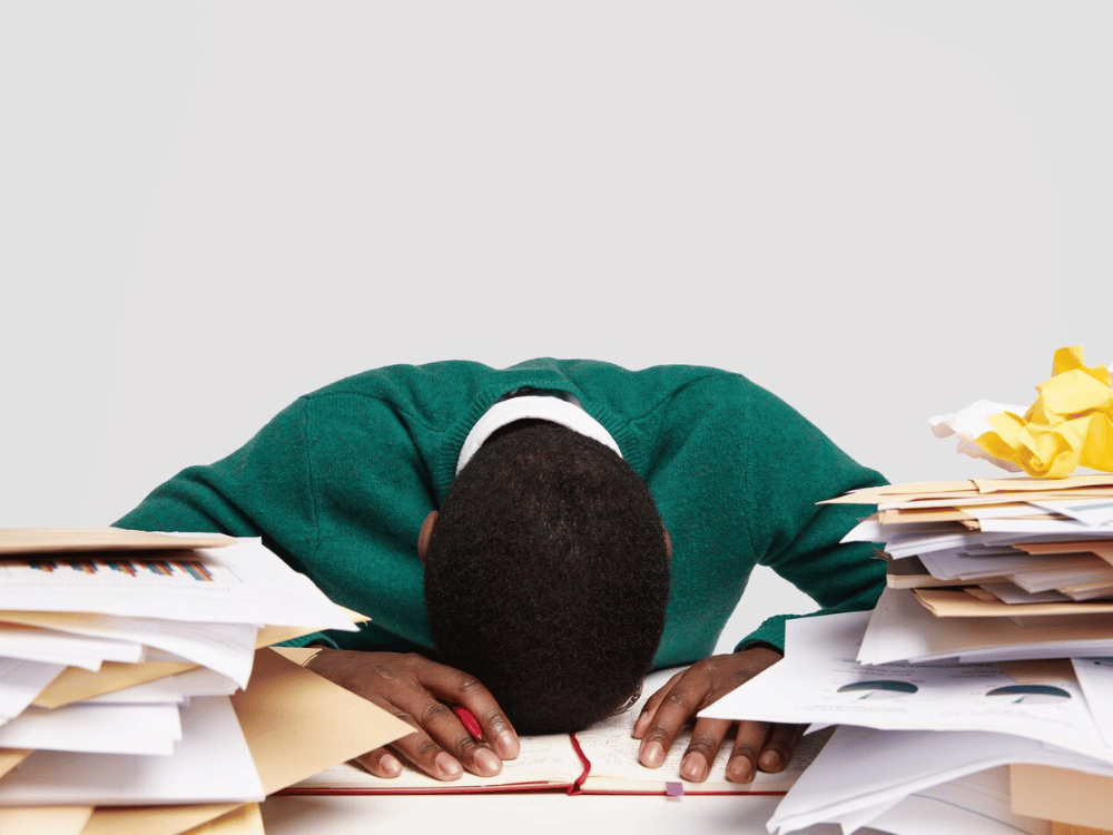 A person is sitting on top of a pile of papers.