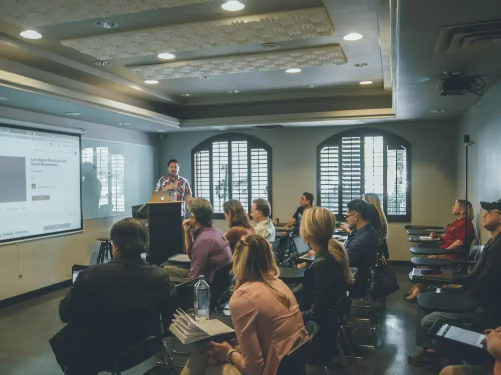 Business seminar in progress with a presenter in a plaid shirt.