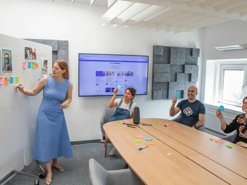 Team members participating in a brainstorming session with sticky notes in a modern meeting room.
