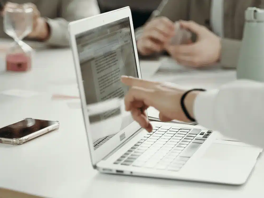 Hands working together on a laptop during a team collaboration session.