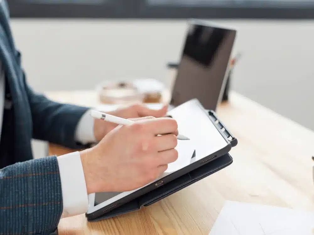 Person sketching on a digital tablet with a stylus.
