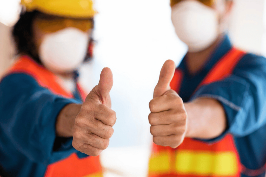 Two construction workers giving thumbs up.