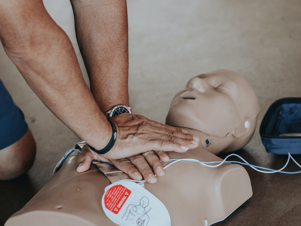 Hands-on CPR demonstration using a practice dummy.