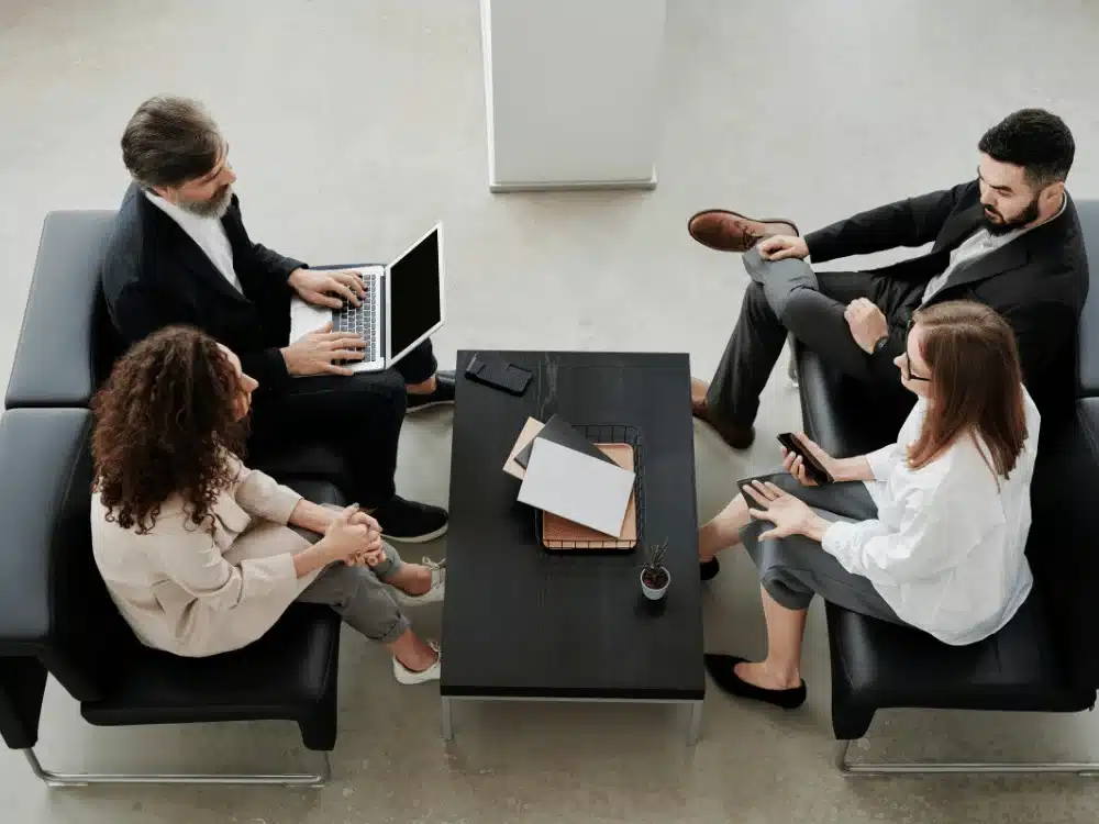 Group of professionals having a business meeting while seated in a modern office lounge.