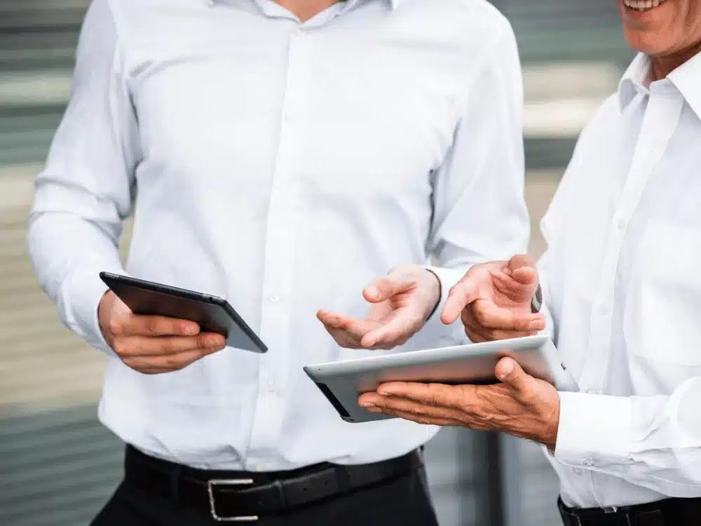 Business colleagues with tablets having a conversation outdoors.