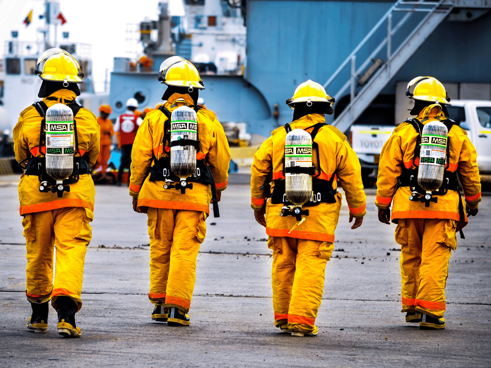 Back view of fire brigade team ready for emergency at dockside.