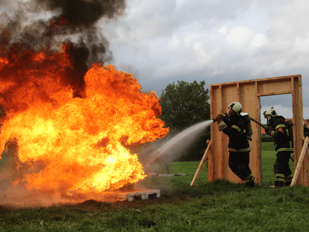 Brave firefighter at work, spraying high-pressure water to control fire.