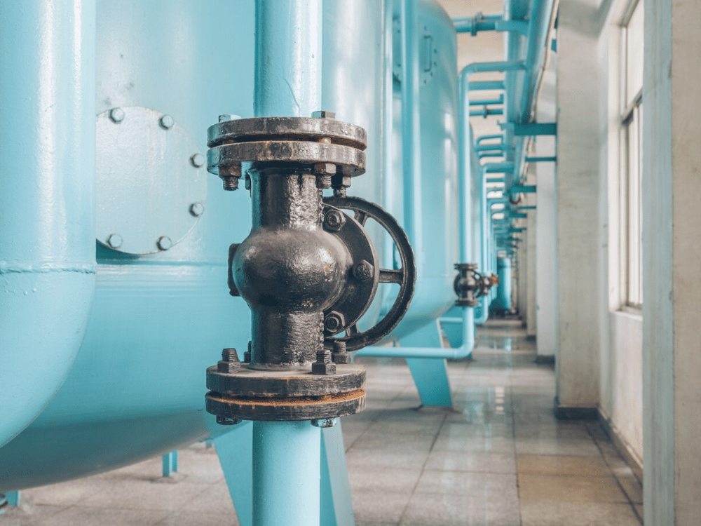 A close up of pipes and valves in an industrial building.