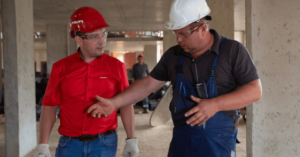 Two construction workers discussing over a plan in a building site.