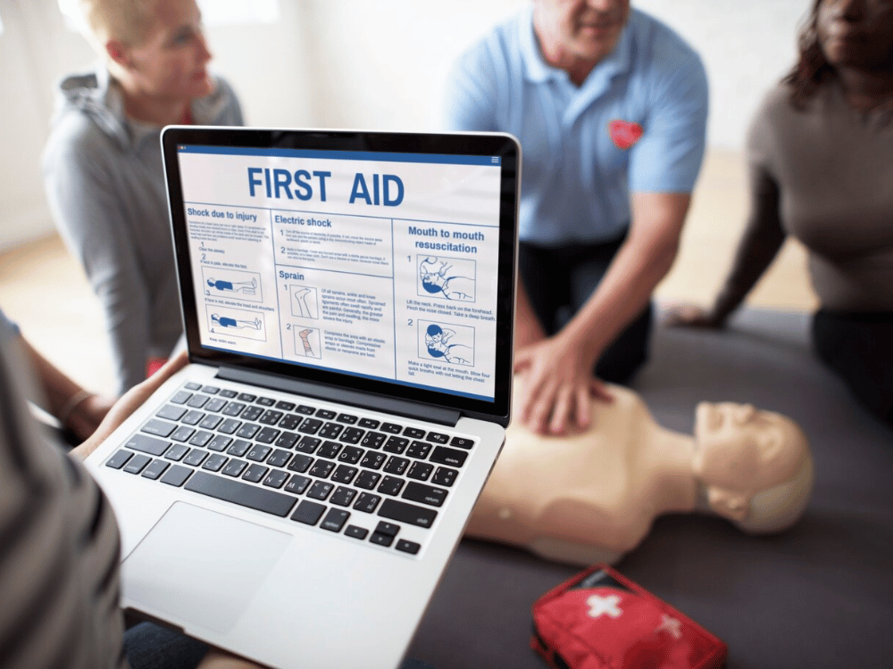 A person holding a laptop with an image of first aid on it.