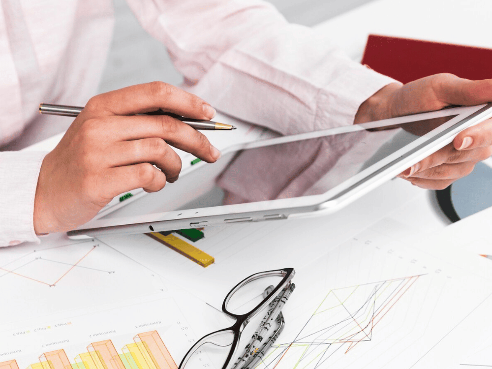 A person is using a tablet with a pen, focusing intently on the screen.