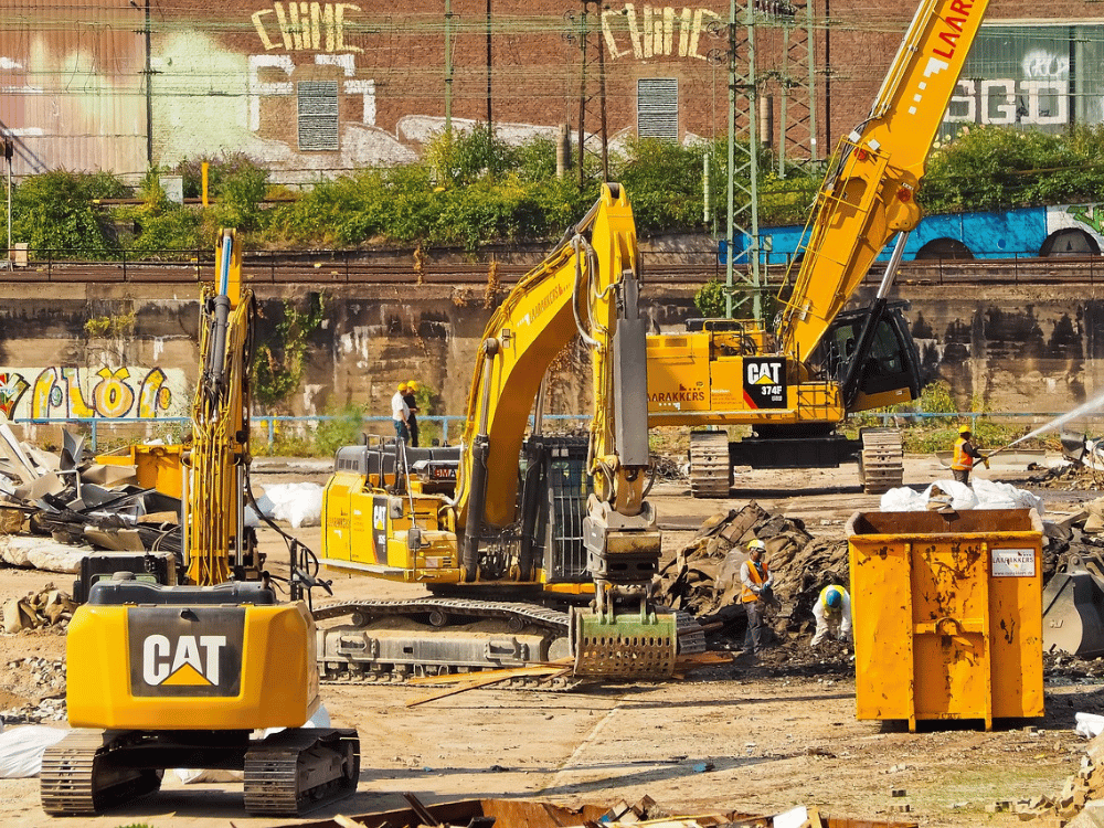 A group of construction equipment in front of a building.
