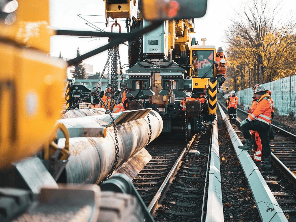 A group of construction workers are working on a train track.