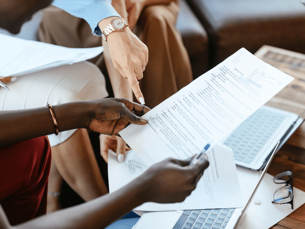Close-up of a business meeting with documents being reviewed by a diverse team.
