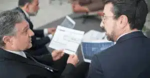 Business professionals discussing financial reports in a modern office setting.