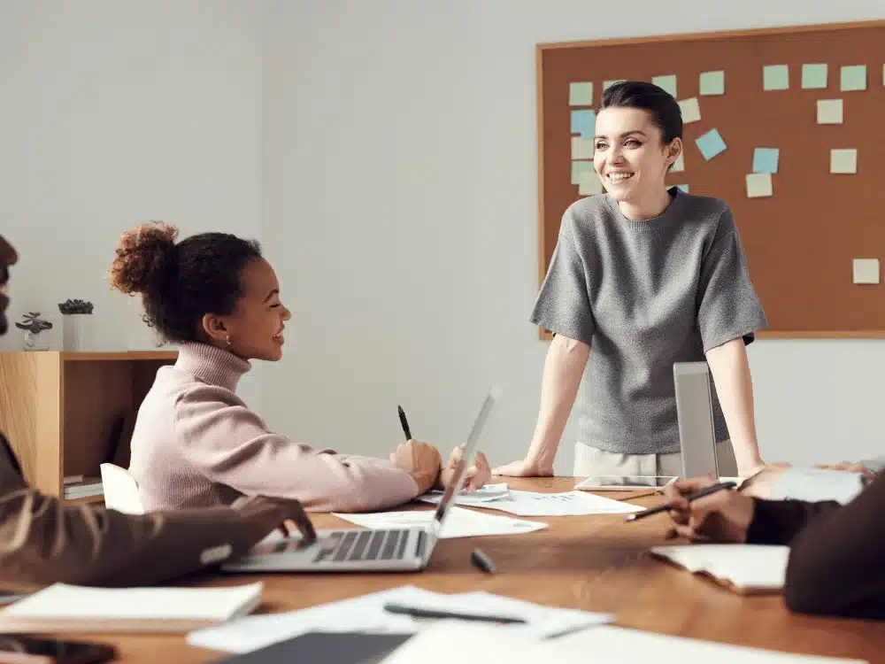 Interactive team session with a confident female presenter and engaged coworkers.