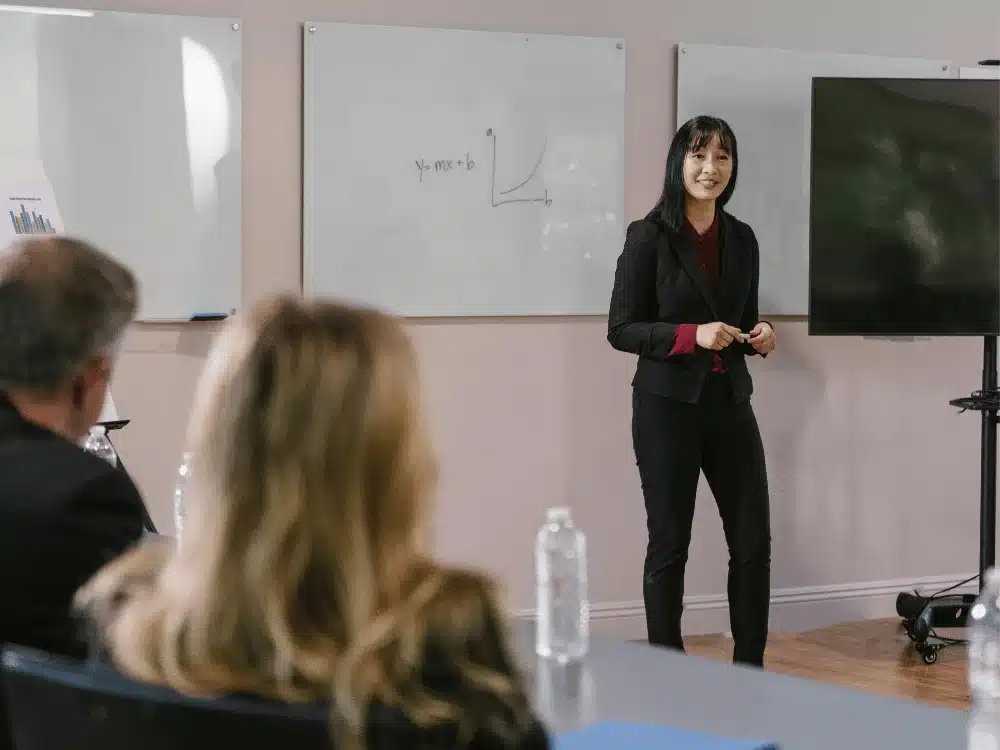 Professional meeting with a woman presenting to colleagues.