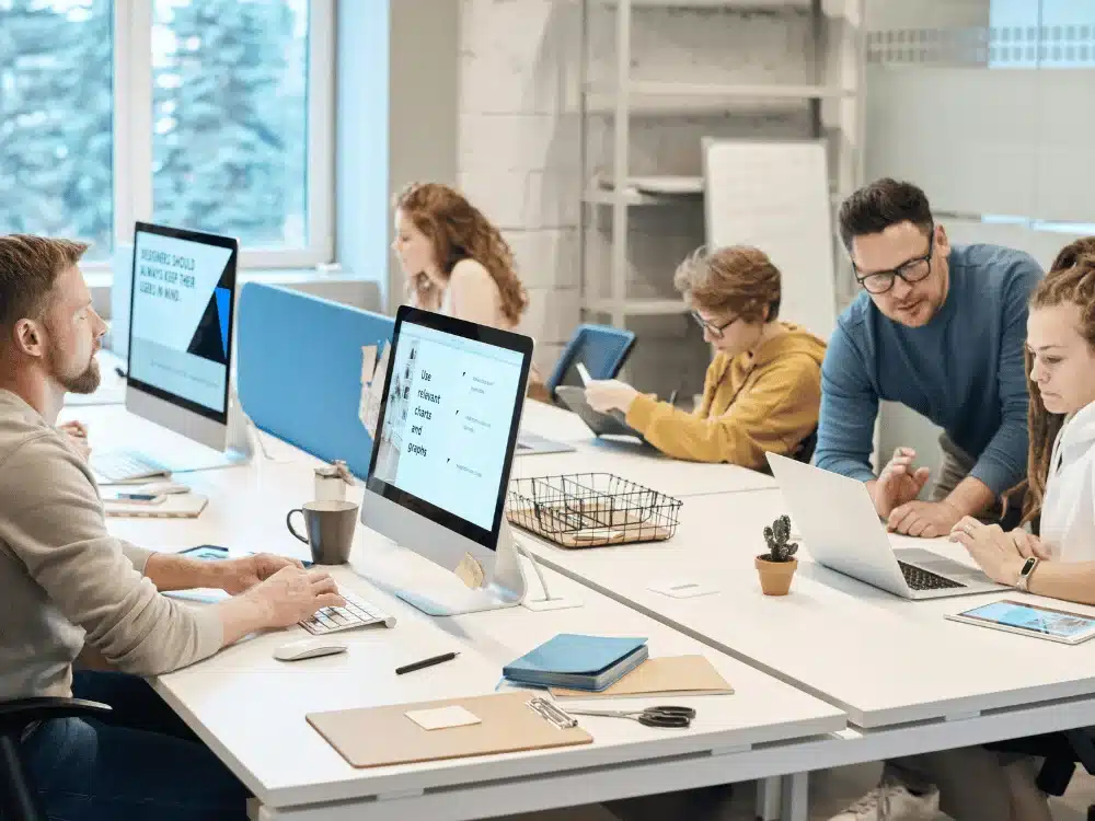 Team members collaborating on a project in a modern, open-plan office space.