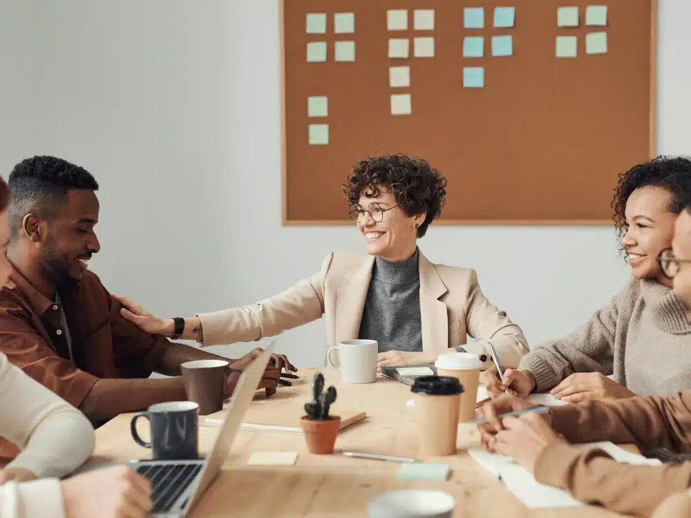 Joyful work meeting with young professionals around a table.