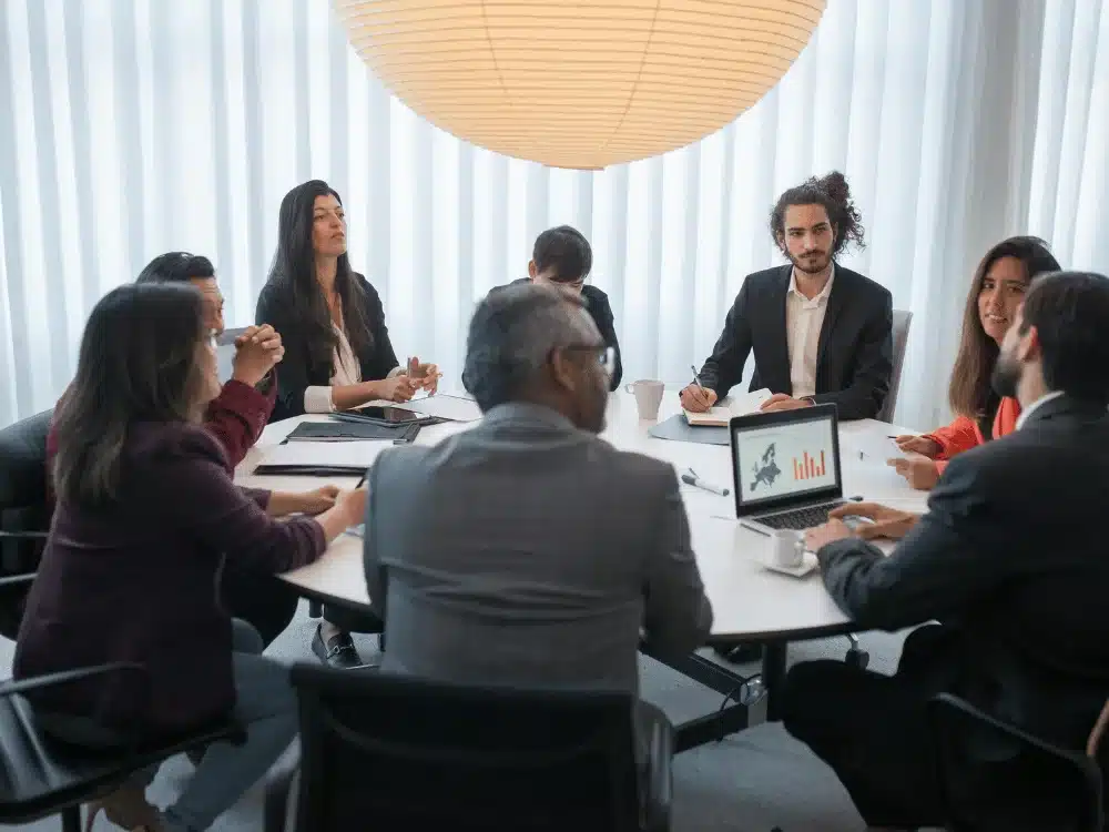 Corporate meeting: team members analyzing data and collaborating on a project.