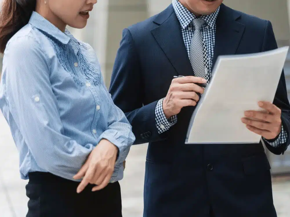 Professional woman and man going over a document, highlighting their collaboration and teamwork.