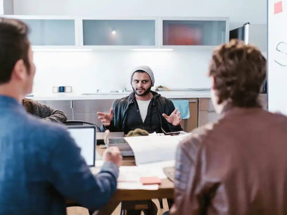Man leading team discussion in modern office setting.