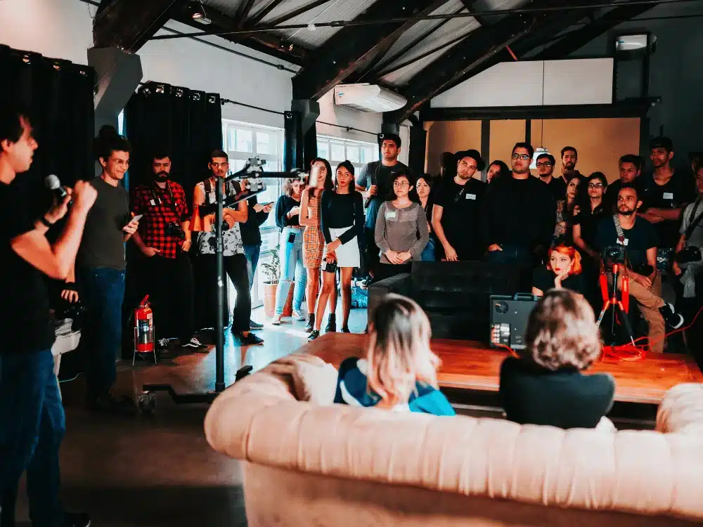 Group of creatives attending indoor presentation event.